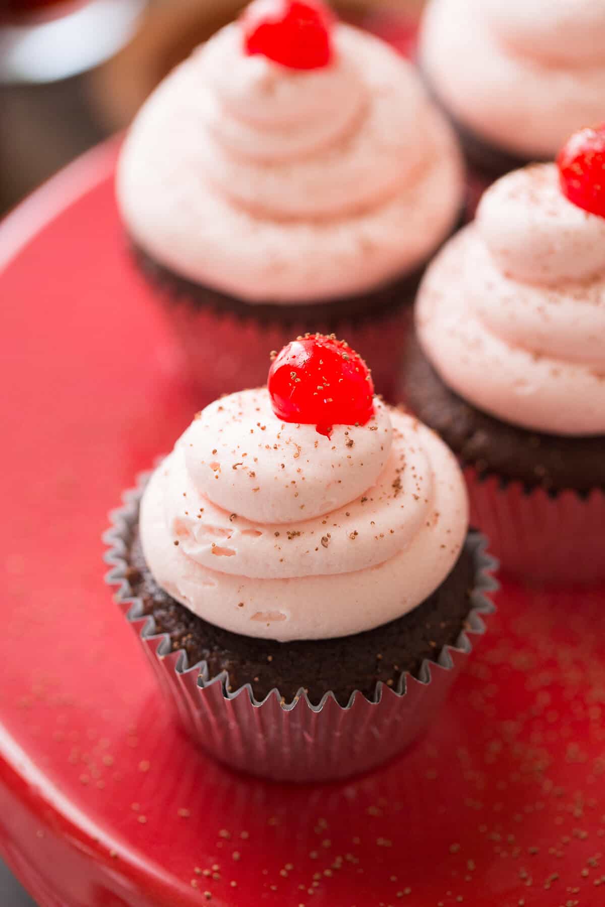 These Cherry Coke cupcakes start with soda infused chocolate cake that gets topped with an ultra creamy cherry buttercream! Each bite is pure delight!