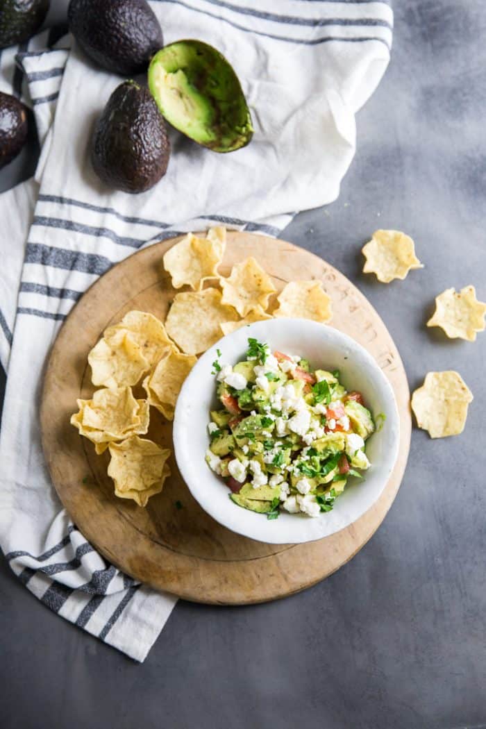 Avocado salsa with chips and avocado on the side