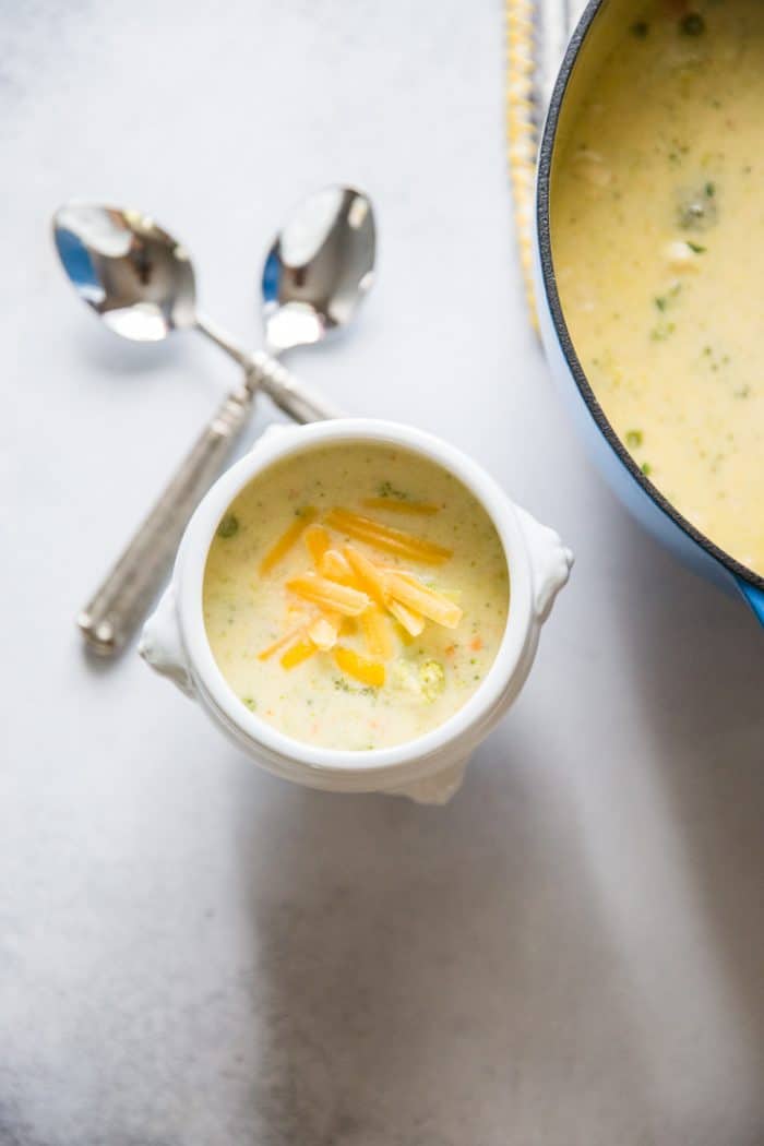 bowl of broccoli cheddar soup and two spoons