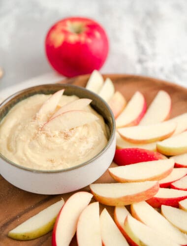 caramel apple dip on a brown plate with apples