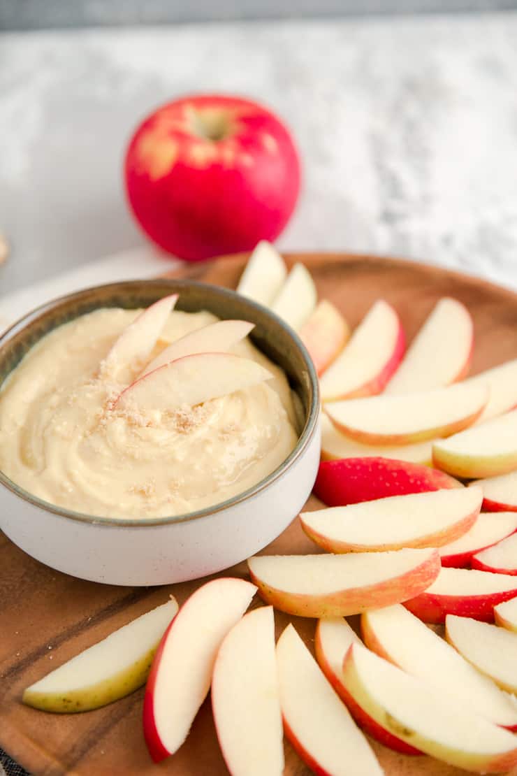 caramel apple dip on a brown plate with apples