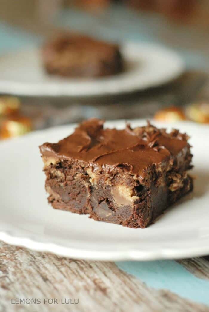 These chocolate peanut butter brownies are sinfully decadent. Lots of rich chocolate, peanut butter and peanut butter cups are crammed into these brownies. A thick and creamy chocolate frosting is layered on top! www.lemonsforlulu.com #hometailgate