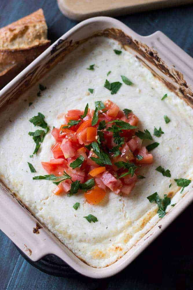This creamy, hot bruschetta dip has three kinds of melted cheese, juicy tomatoes, and fresh herbs. It will be a hit anywhere it is served! | lemonsforlulu.com