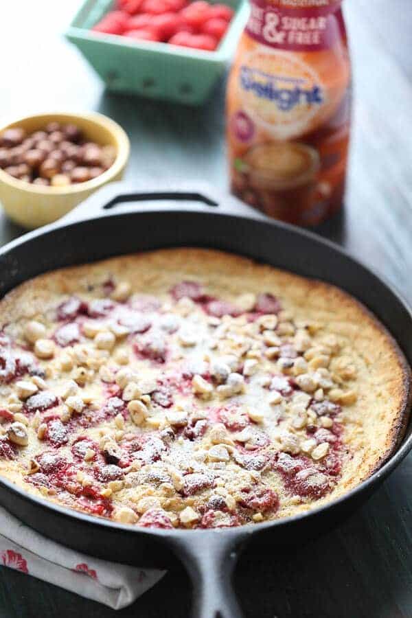 Fresh raspberries and crunchy toasted hazelnuts grace this simple Dutch baby! Enjoy this for breakfast, brunch or dessert! #IDelight #Ad