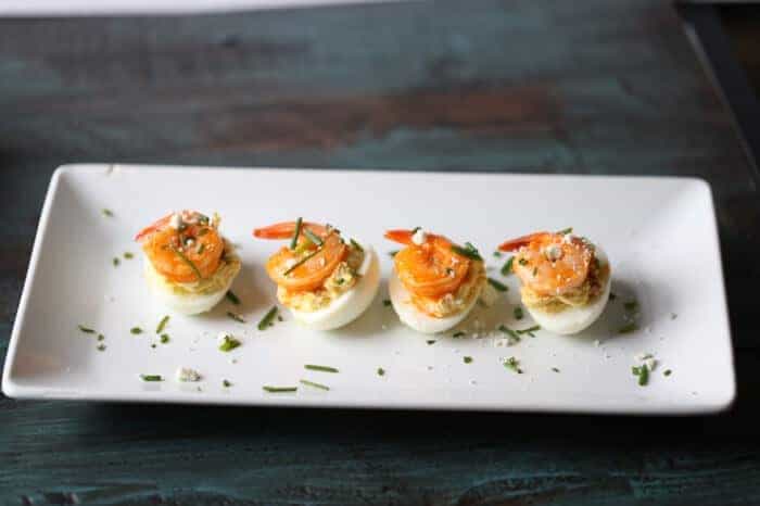 These Buffalo shrimp deviled eggs will be a hit wherever they go! The spicy shrimp are tamed by the tang blue cheese filling. Time to rethink the way you do deviled eggs! #OhioEggRoll