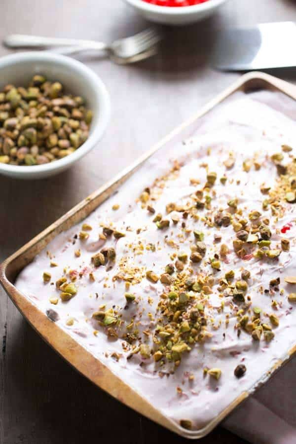 Sweetened condensed milk, maraschino cherry, pistachios and chocolate cake helps this easy poke cake come together! lemonsforlulu.com