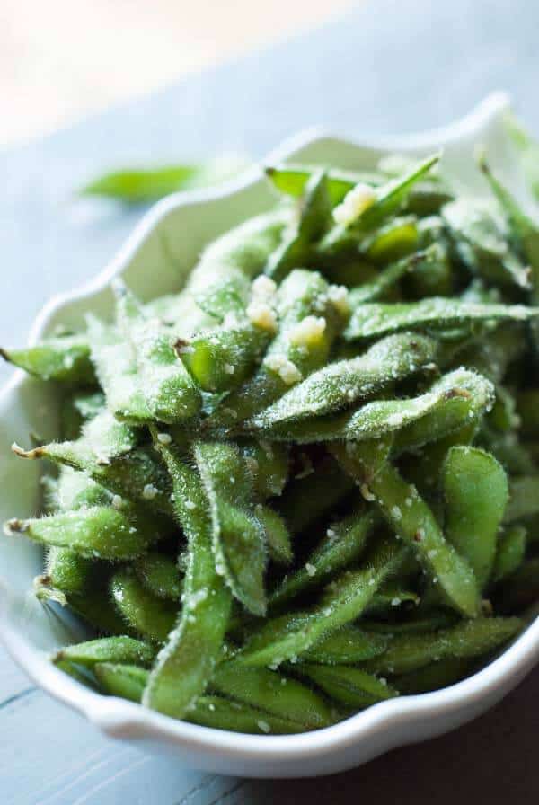 Edamame is steamed then coated in olive oil, garlic and Parmesan Cheese! Enjoy these pods as a side or even as a snack! lemonsforlulu.com