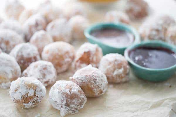This ricotta donuts recipes is a sweet lovers dream! Tender little donuts are lightly fried then covered in powdered sugar. Serve these bundles with both raspberry and caramel dipping sauce! lemonsforlulu.com