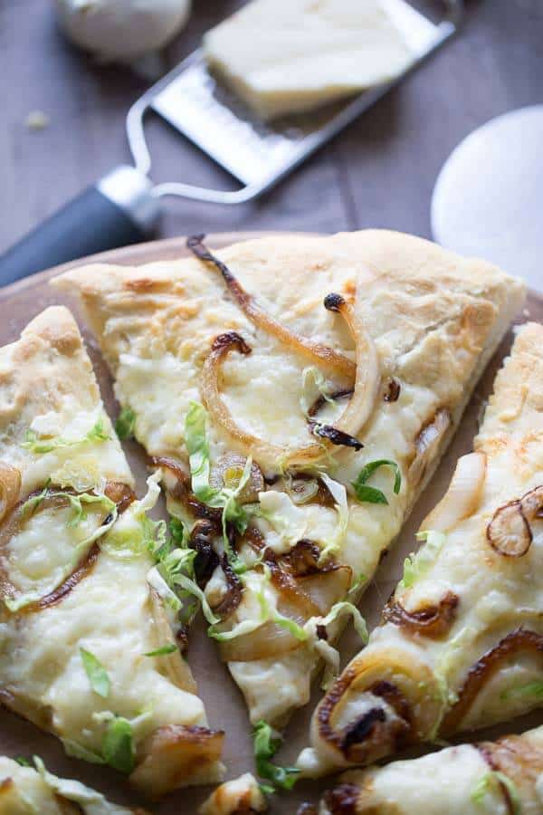 Caramelized onions and Brussels sprouts top off this easy to make homemade pizza! lemonsforlulu.com