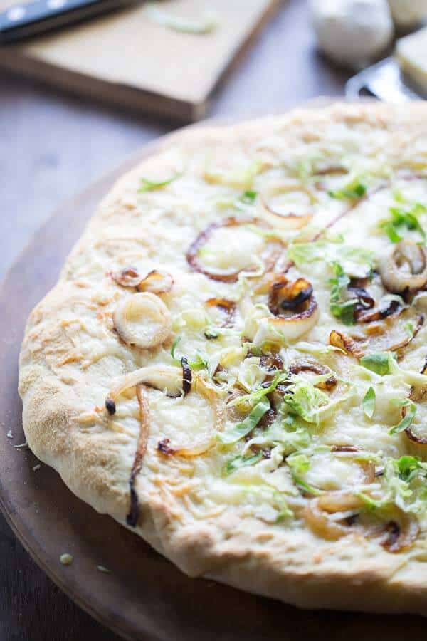 Homemade pizza dough is quicky and easy! This pizza is topped simply with caramelized onions, fontina cheese and Brussels sprouts! lemonsforlulu.com