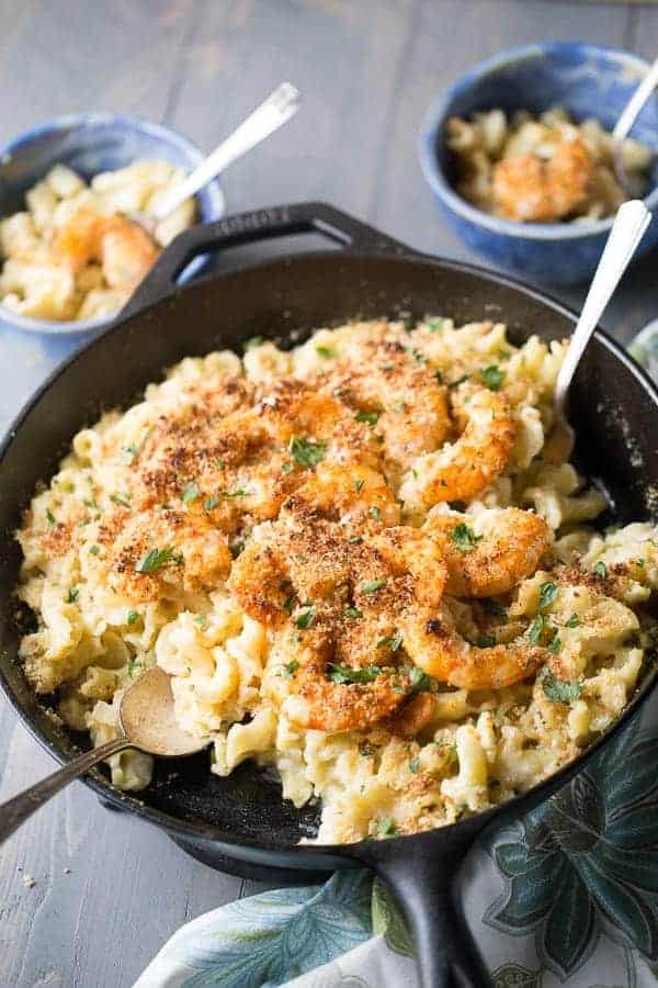 Cast iron skillet full of a delicious Cajun Shrimp Mac and Cheese recipe with a silver spoon.