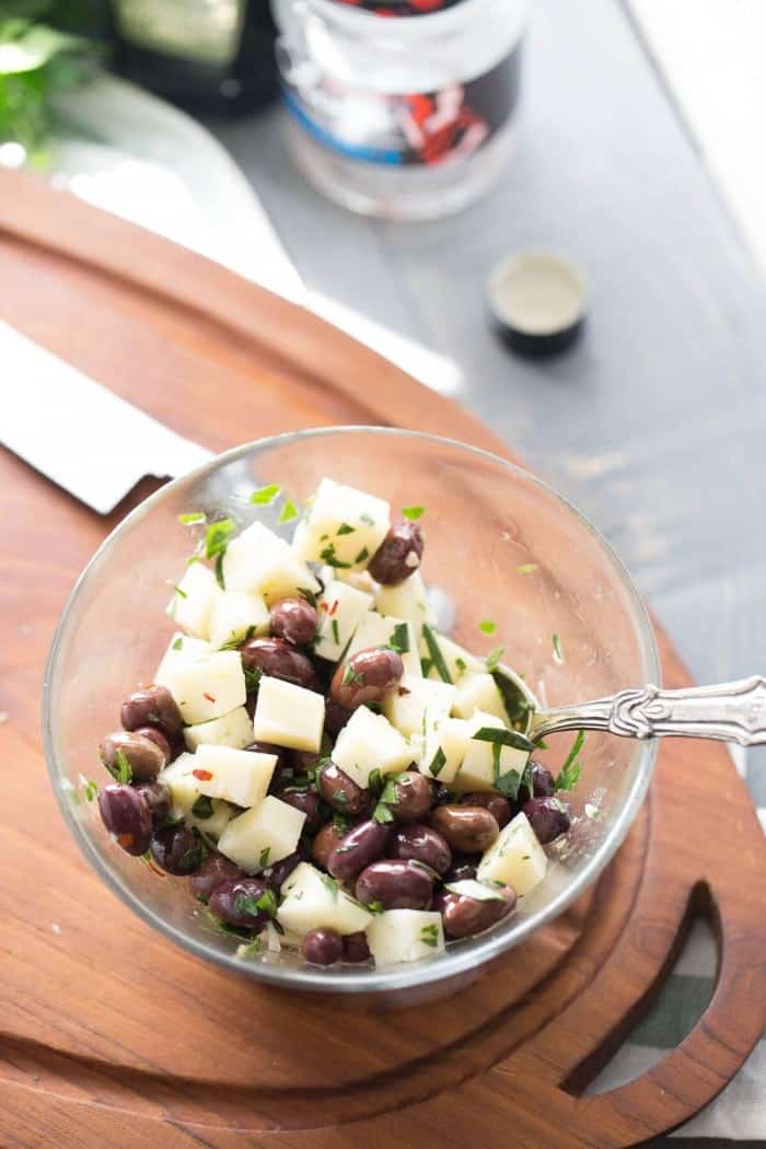 Spanish olives soak up olive oil and spices and then are tossed with manchego cheese for a piquant appetizer that is simple yet elegant.