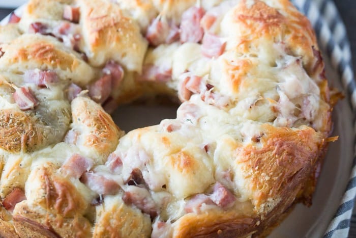 Skip the sandwich, this ham and swiss monkey bread recipe is what you want instead! Seasoned biscuits, savory ham and creamy swiss cheese make this monkey bread an absolute crown pleaser!