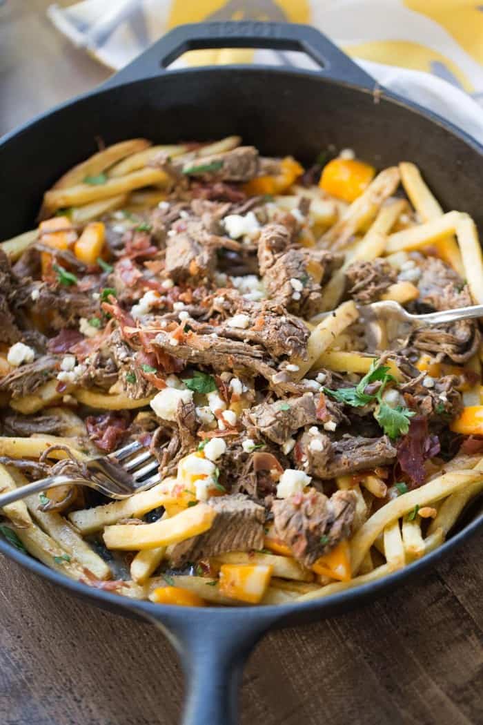 French fries have found the perfect partner in this poutine recipe! Crispy French fries are topped with slow cooked brisket, gravy, bacon and two kinds of cheese for a meal that is out of this world!