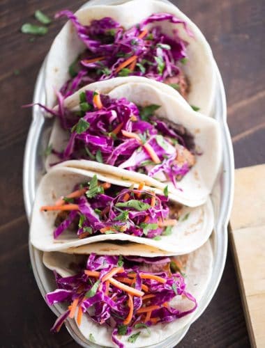 Grilled steak tacos have a fusion flair! Ginger infused cabbage and garlic beans make these tacos full of flavor!