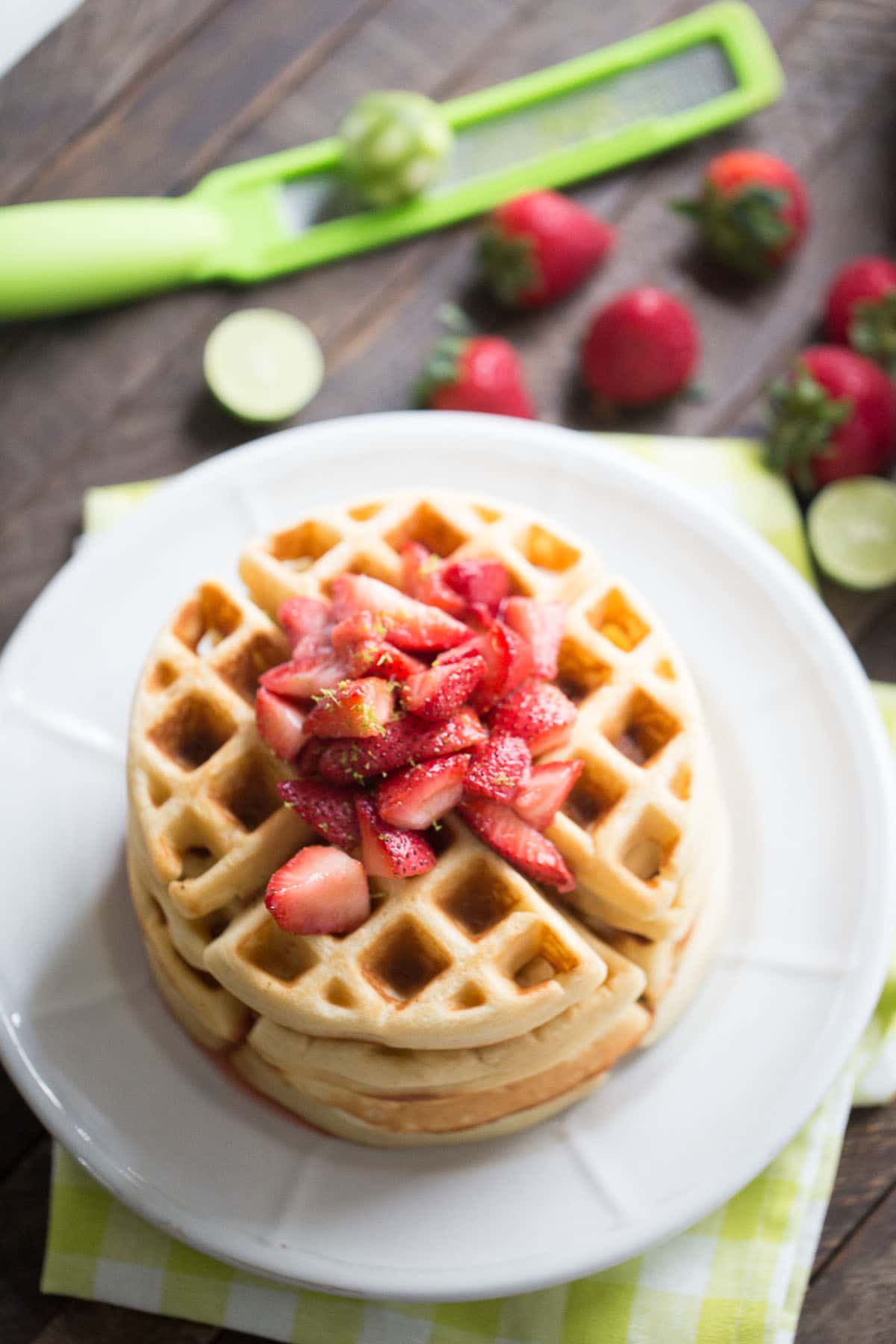Who doesn't love waffles? This easy homemade waffles recipe is bursting with key lime flavor and is topped with a simple homemade strawberry sauce!