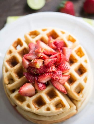 This easy homemade waffles recipe gets a tangy kick from key lime and is served with a sweet strawberry topping.