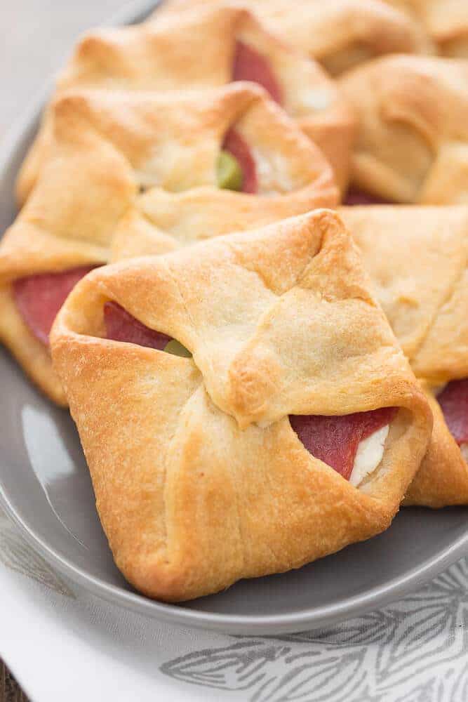 Bundles made with crescent dough are filled with cream cheese, herbs, salami and pickles. A surprising good break from the ordinary!