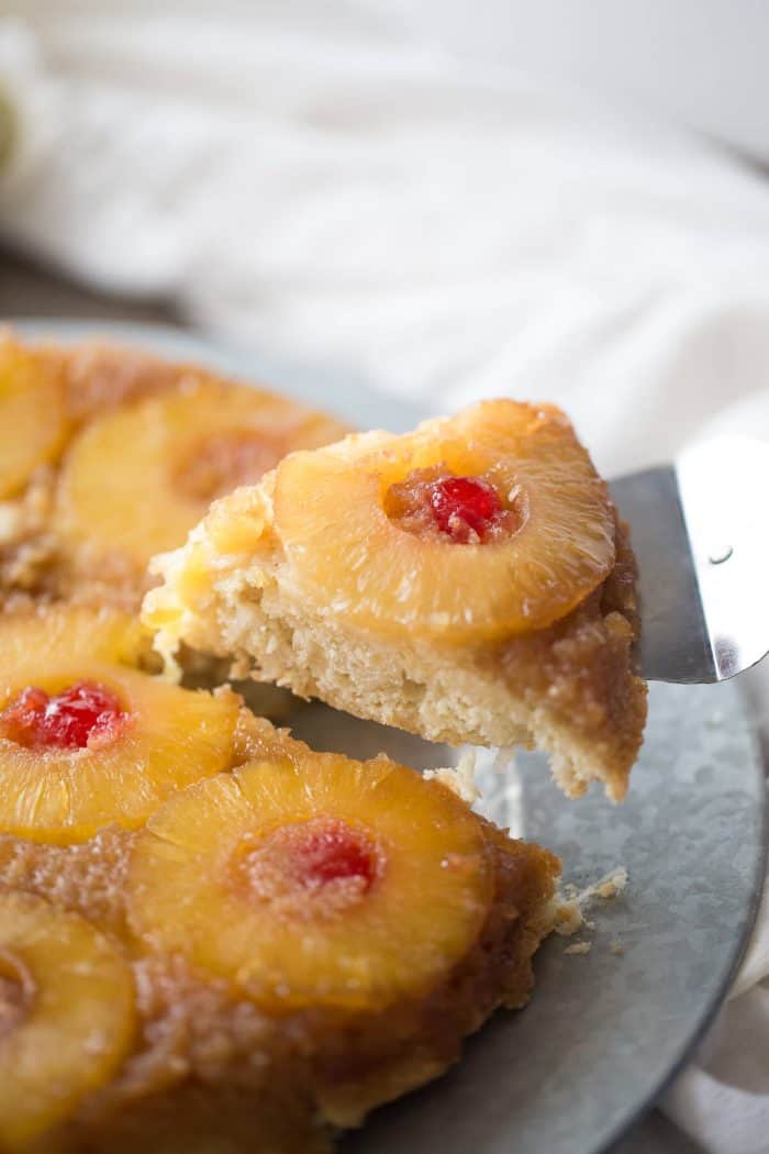 Upside down cake takes a tropical turn! This easy cake recipe has pineapple and cherries resting in a caramel sauce while the cake itself has shredded coconut and a hint of rum!