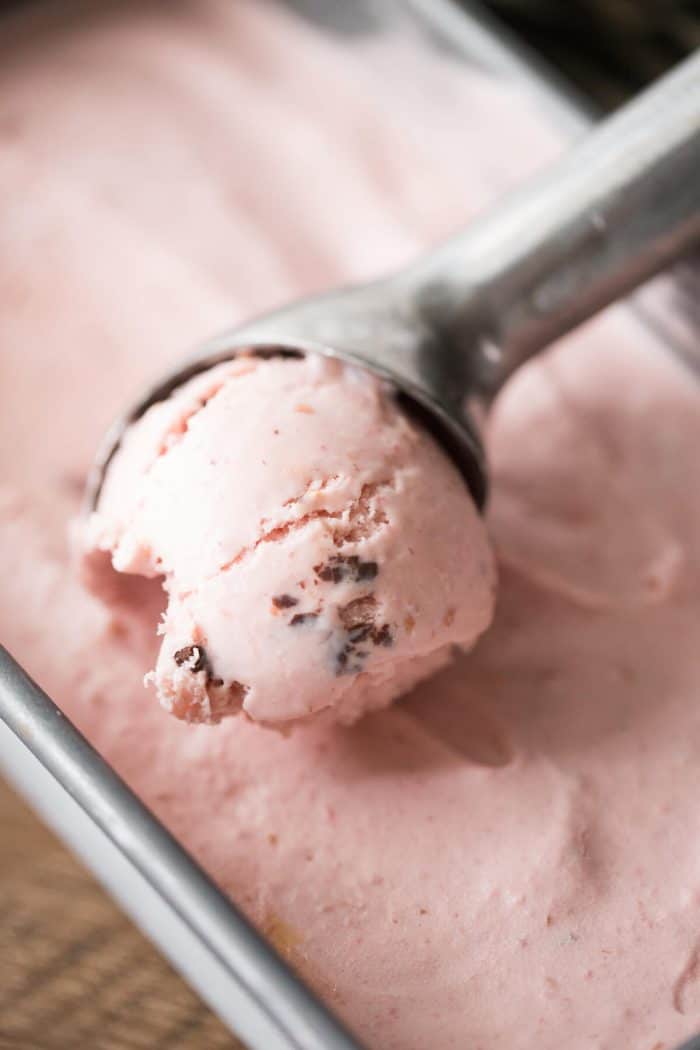 Scooping delicious raspberry ice cream with an ice cream scooper.