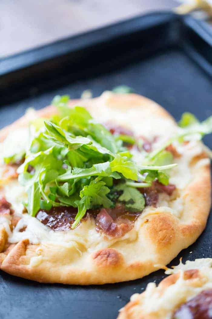To make this naan pizza, naan bread is topped with creamy fontina cheese, salty prosciutto and sweet fig jam. The combination is sensational! | LemonsForLulu.com