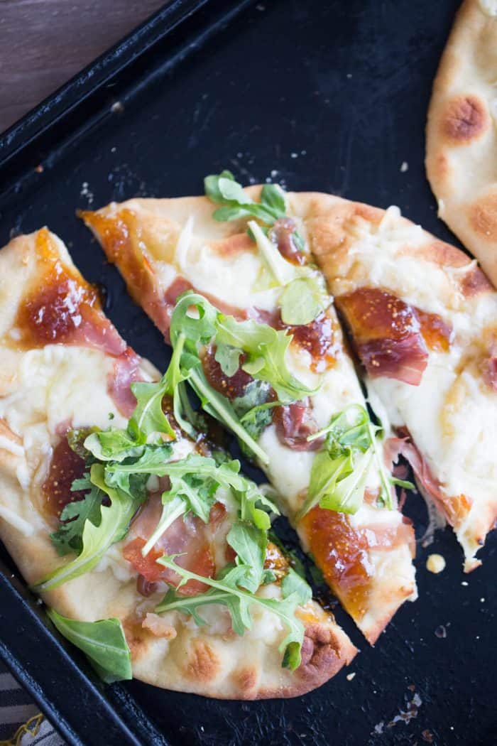 Creamy fontina cheese, salty prosciutto and sweet fig jam. are baked on naan bread to make this easy Naan Pizza. The combination is sensational!
