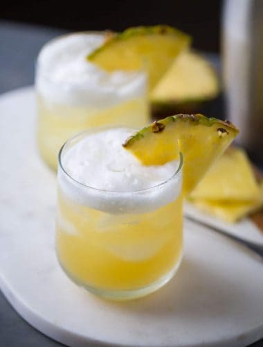 Pineapple Bourbon Punch - Bourbon, sweet pineapple juice, and hazelnut liqueur are shaken together for a tropical tasting drink.