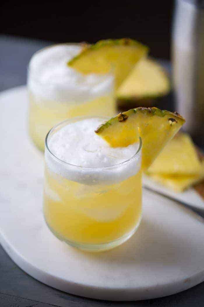 Pineapple Bourbon Punch - Bourbon is infused with hazelnut liqueur and sweet pineapple juice. The combination of flavors is tropical and earthy all at once! | lemonsforlulu.com
