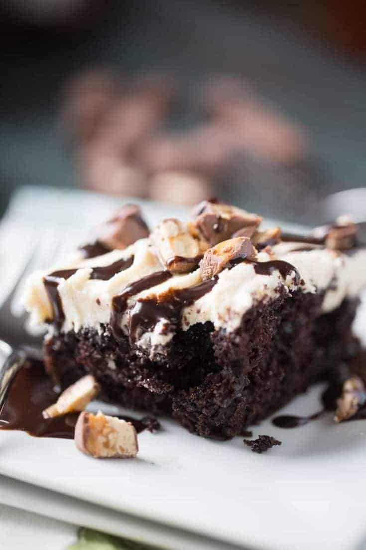 This Snickers poke cake begs for a tall glass of milk! This chocolate cake is so sinfully delicious!