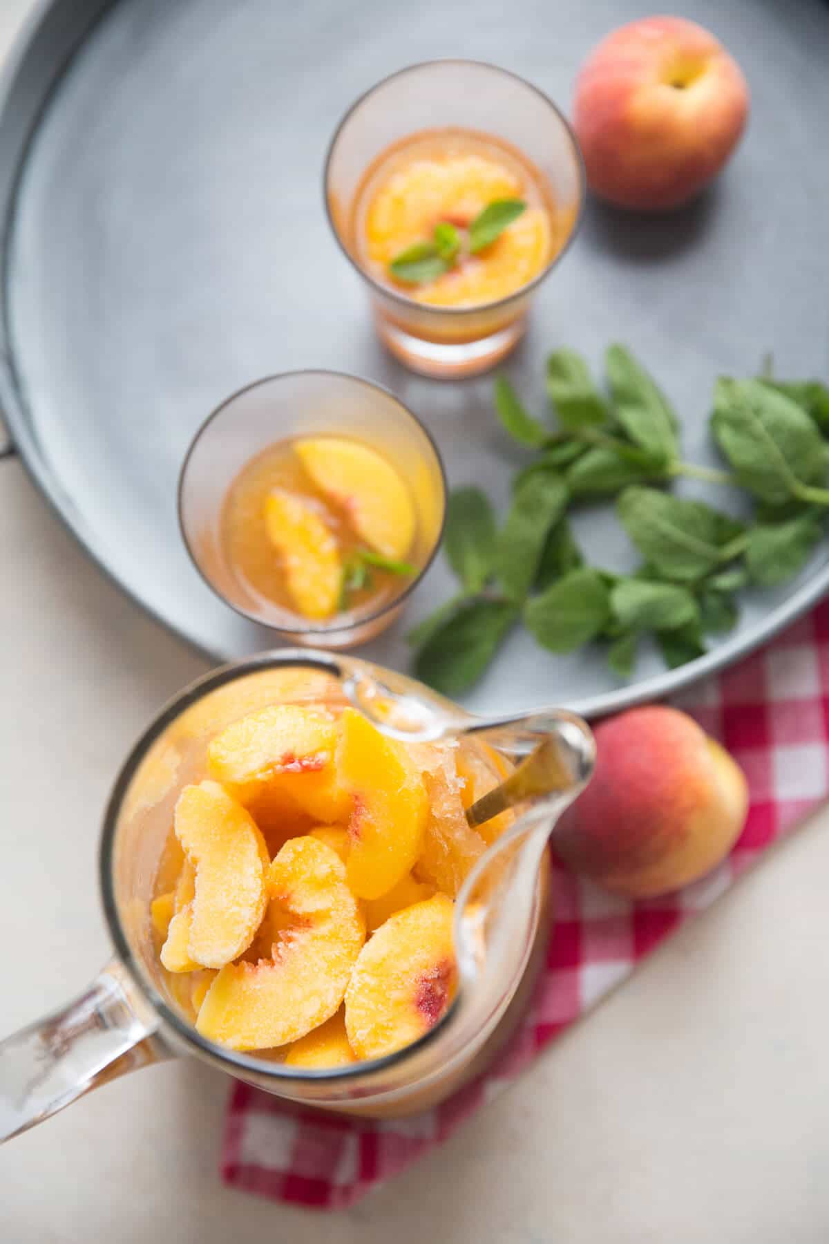 Slush bourbon punch is a perfect party beverage. This peach version bring the sweet fruit of summer in every glass!