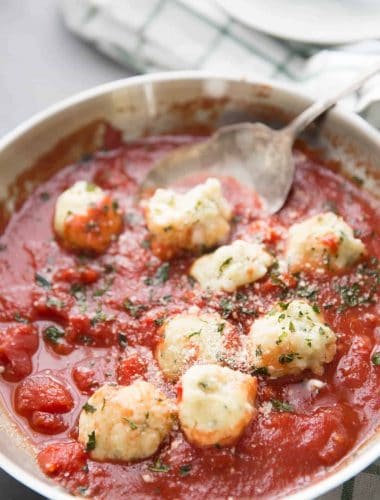 Soft ricotta dumplings are filling and delicious when simmered in a simple homemade marinara sauce! This is comfort food at it's best!