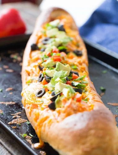 This chicken enchilada bread makes dinner simple! Chicken and sauce are stuffed inside French bread and baked! You decide on the toppings!