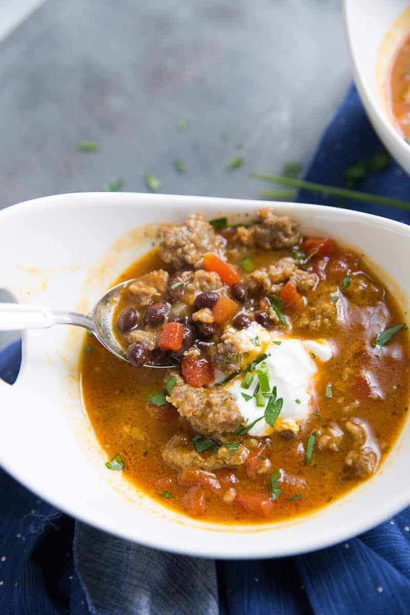 This black bean chili has a little something special; pumpkin!  This easy chili is filled with black beans, Italian sausage, spices, and pumpkin. This filling black bean chili is just what you need when you need a little warming!