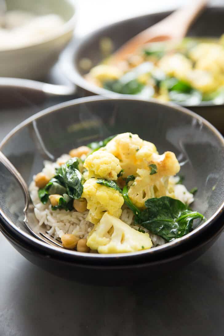 It's easy going meatless with this easy Vegetarian Curry.  Cauliflower, garbanzo beans, and spinach are cooked in a coconut sauce that is rich and silky!