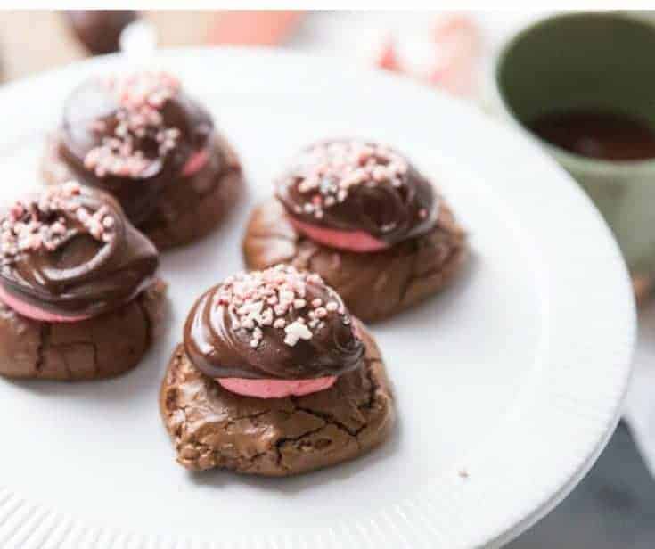 Four delicious chocolate peppermint cookies on a large white serving plate.