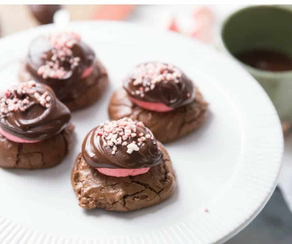 Four simple chocolate peppermint cookies on a white serving plate.