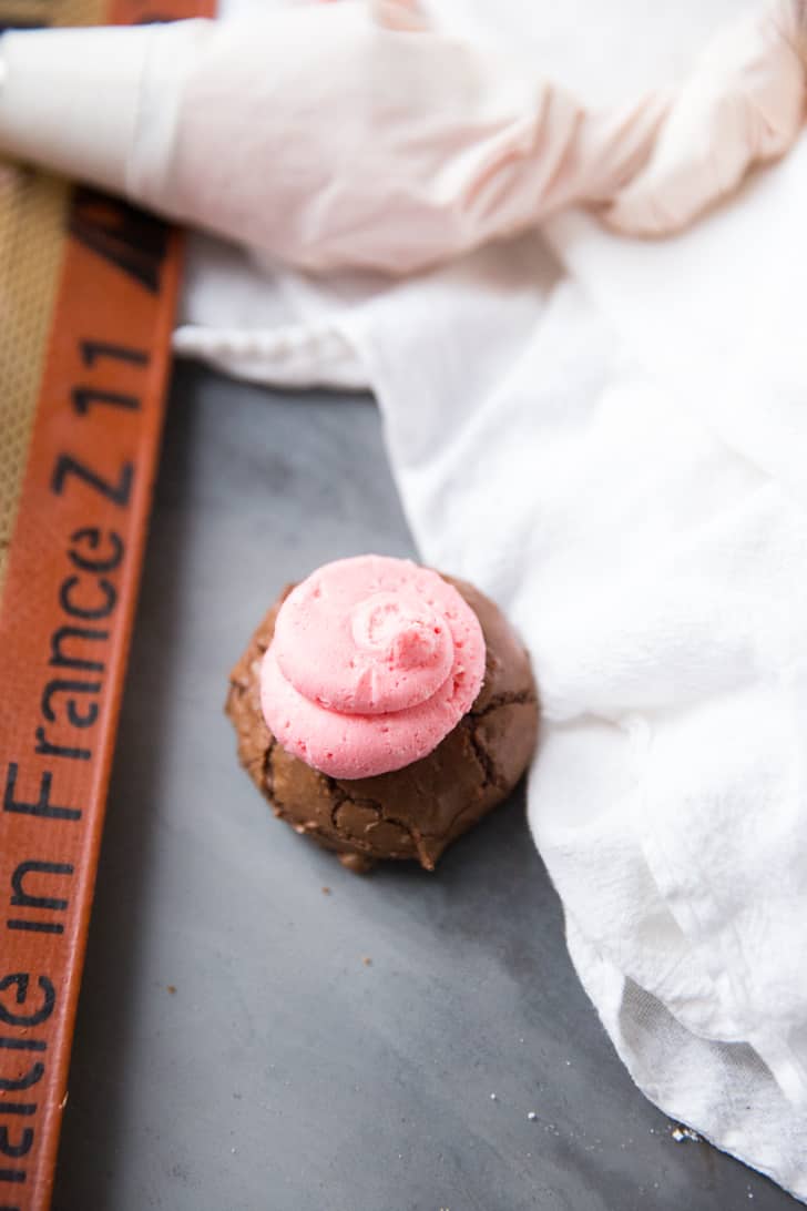 Pink frosting on one Chocolate Peppermint Kiss Cookie.