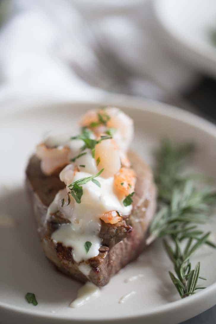 steak on a plate with shrimp on top