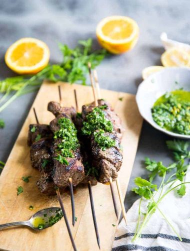 Beef shish kabobs with chimichurri sauce on beef and on the side