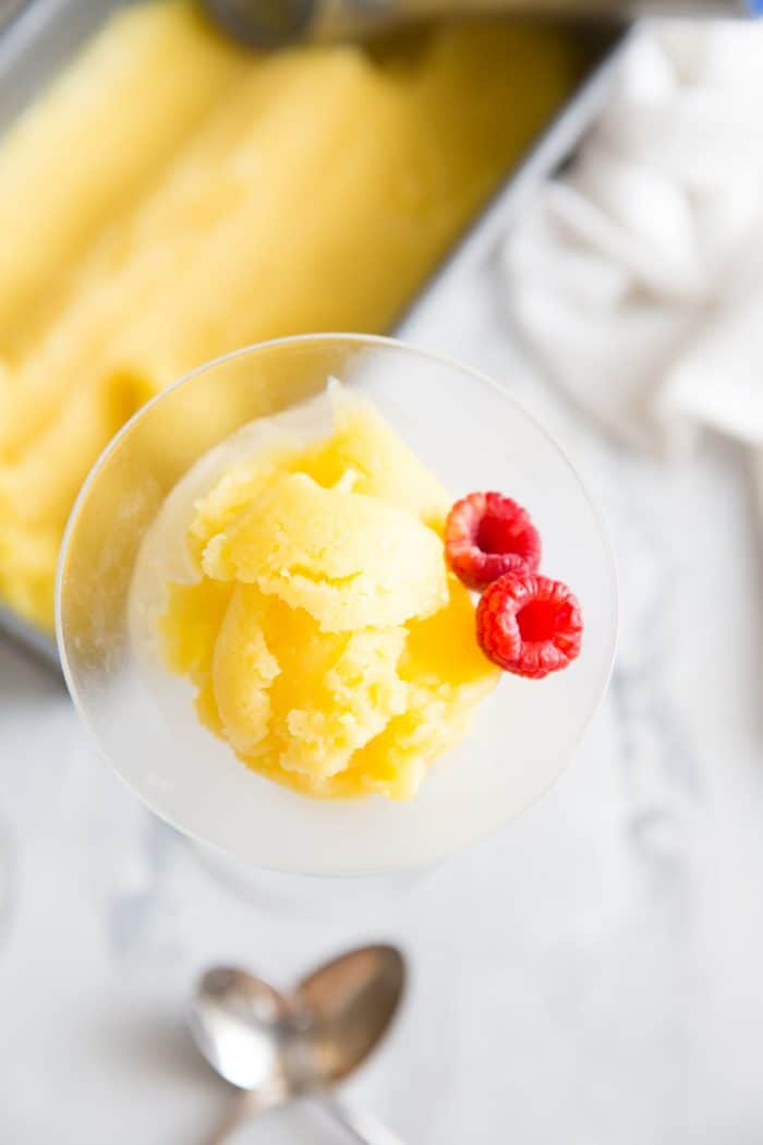 mango rum punch sorbet single glass with two raspberries