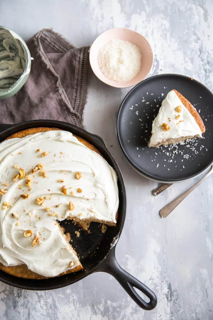 Hummingbird cake in skillet with a slice on the side