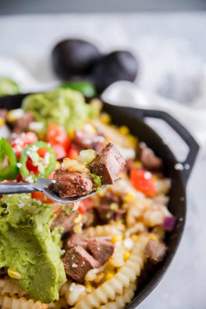 carne Asada fries with a fork