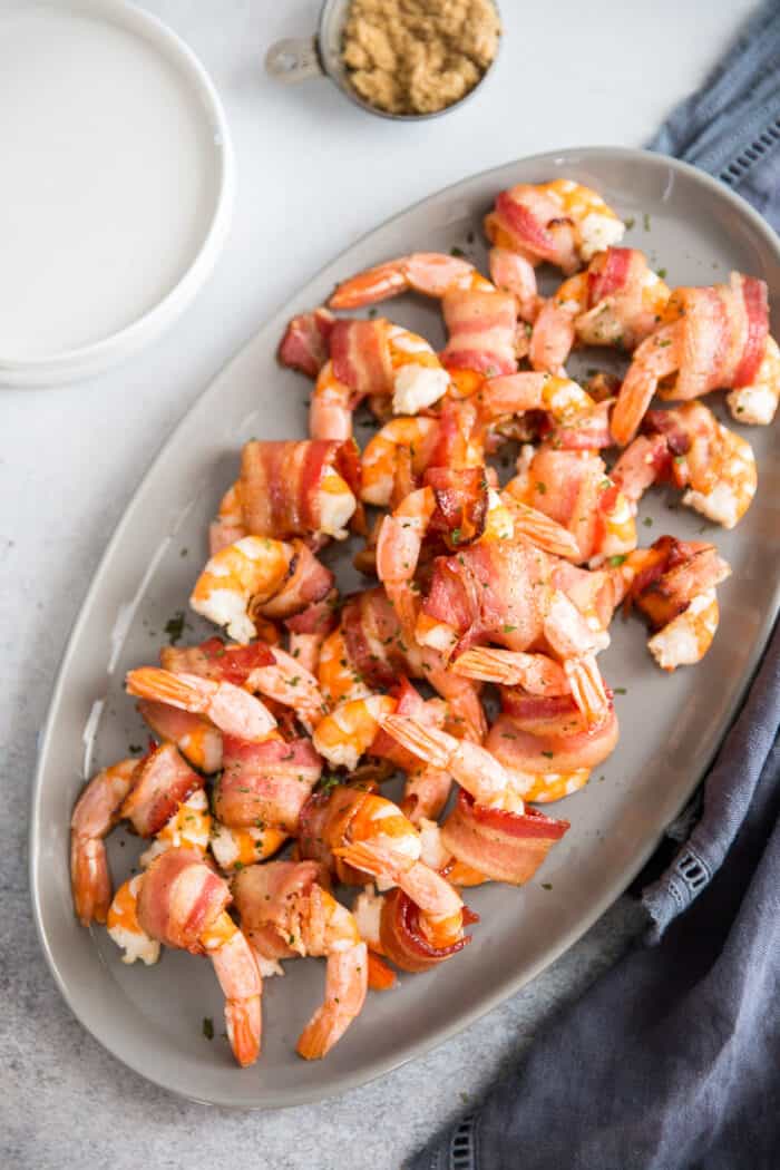 bacon wrapped shrimp arranged on a plate