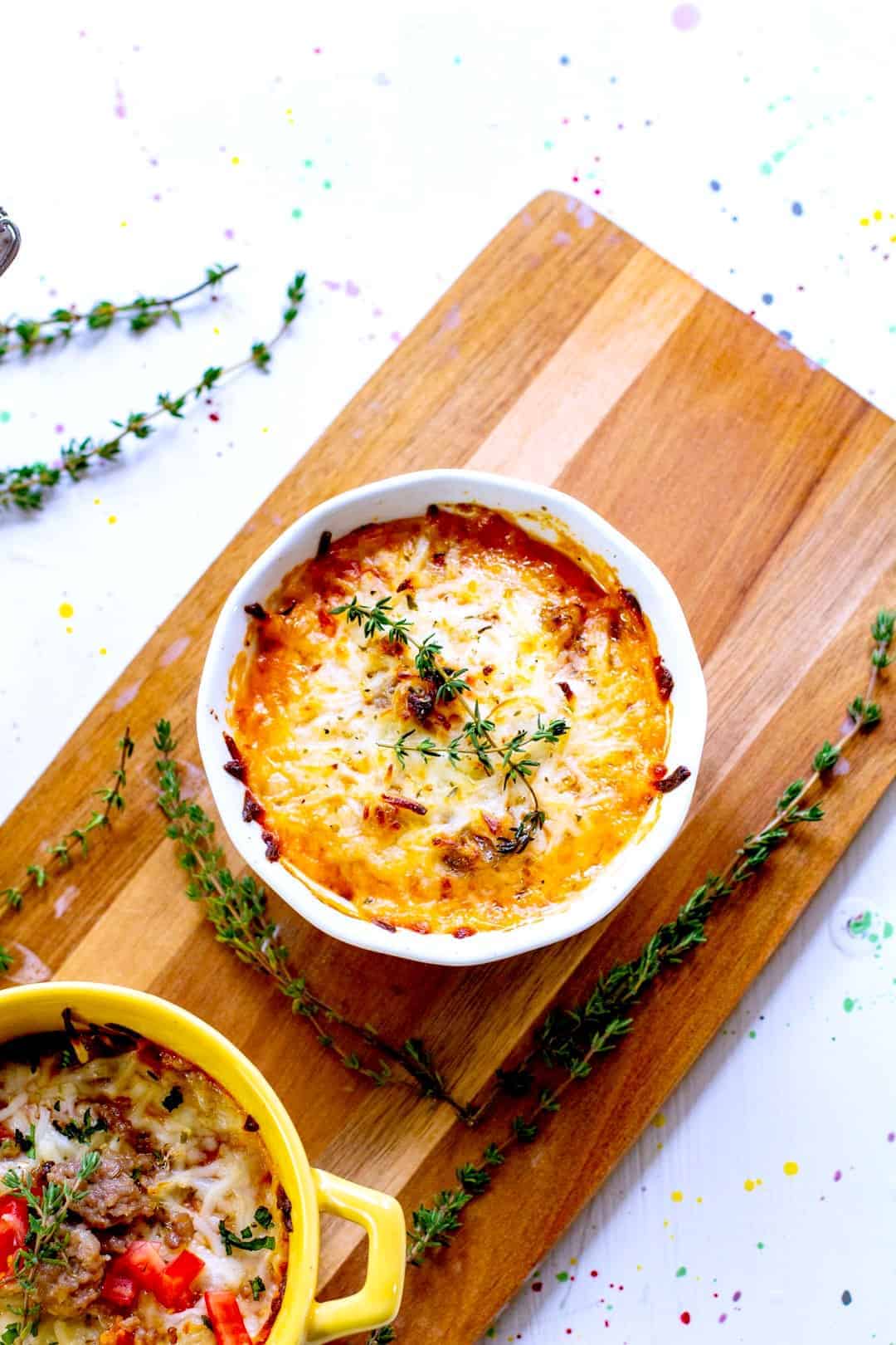 A bowl of food on a table, with Cheese and Macaroni