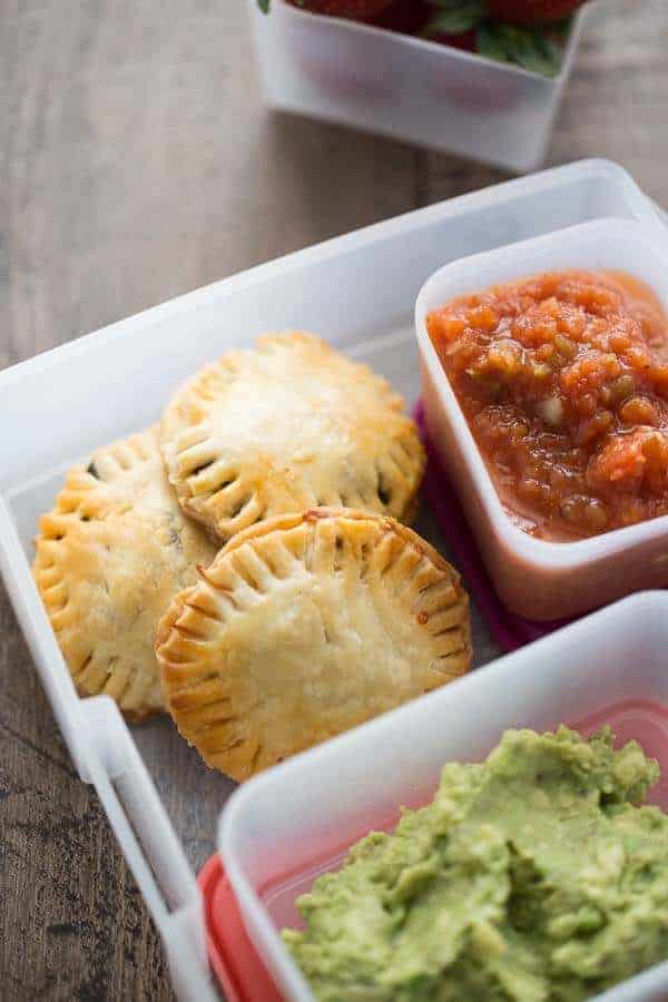 A box filled with different types of food and taco hand pies