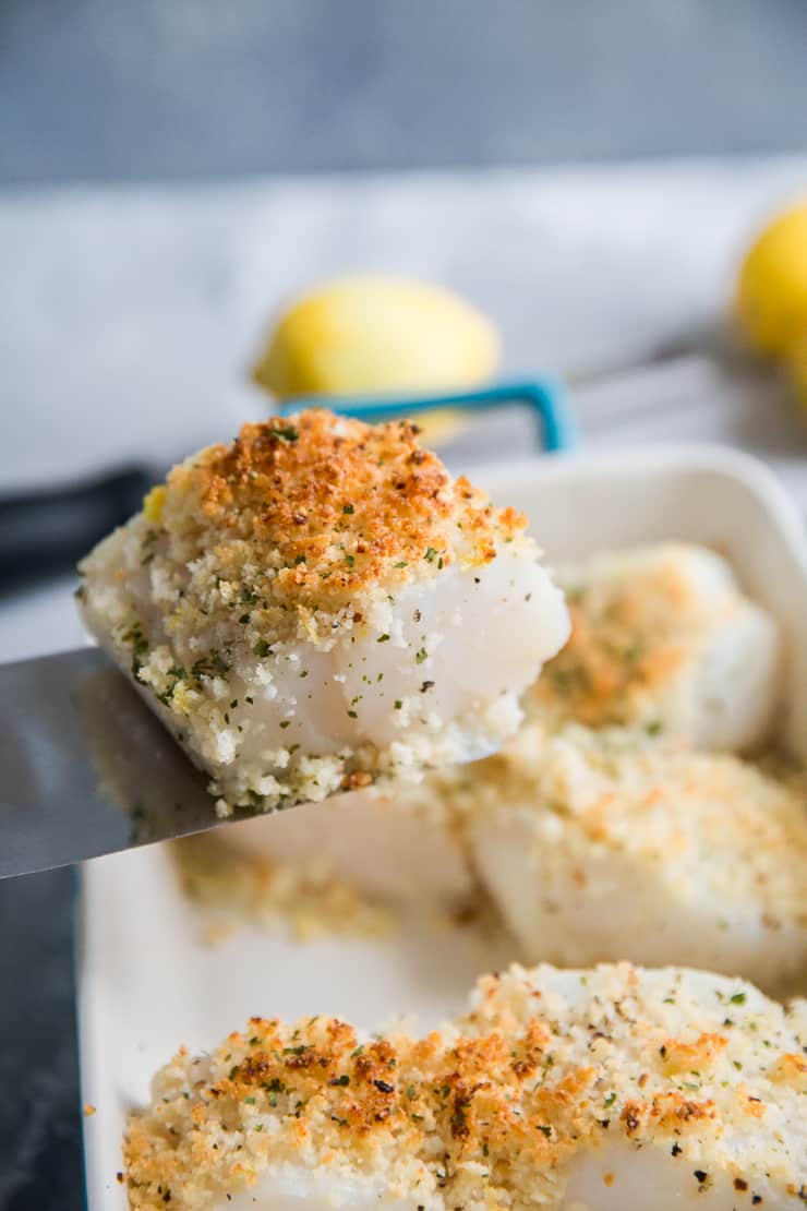 baked cod lifted out of dish