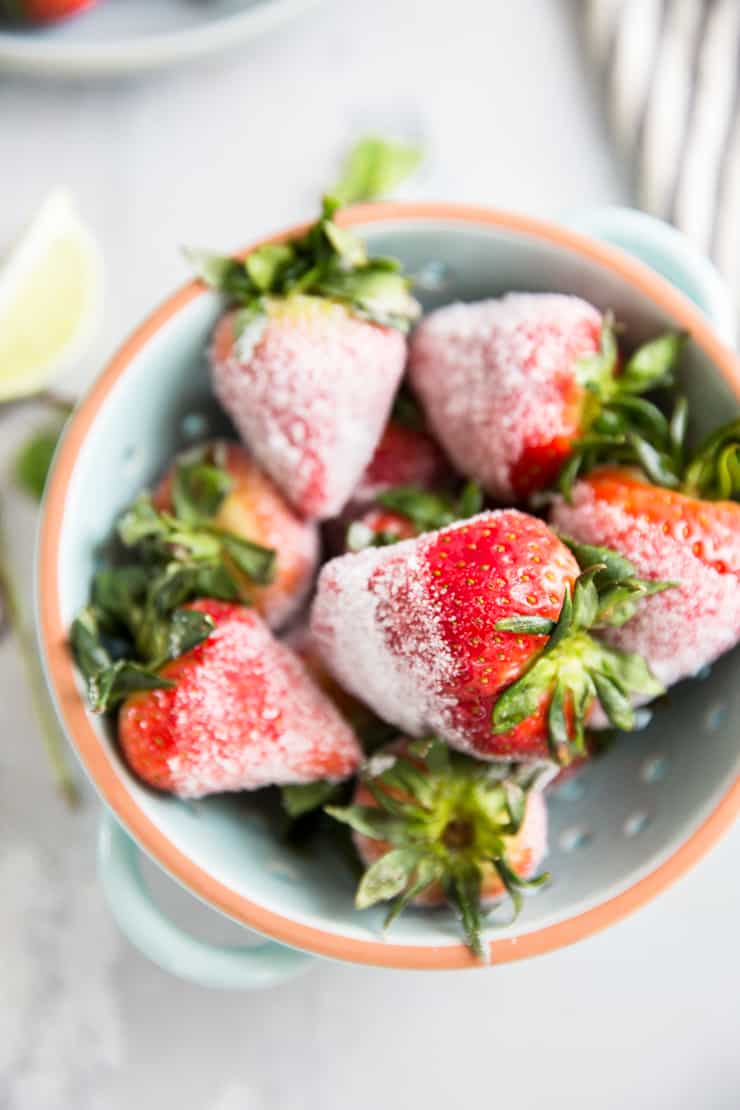 infused strawberries in a blue colander