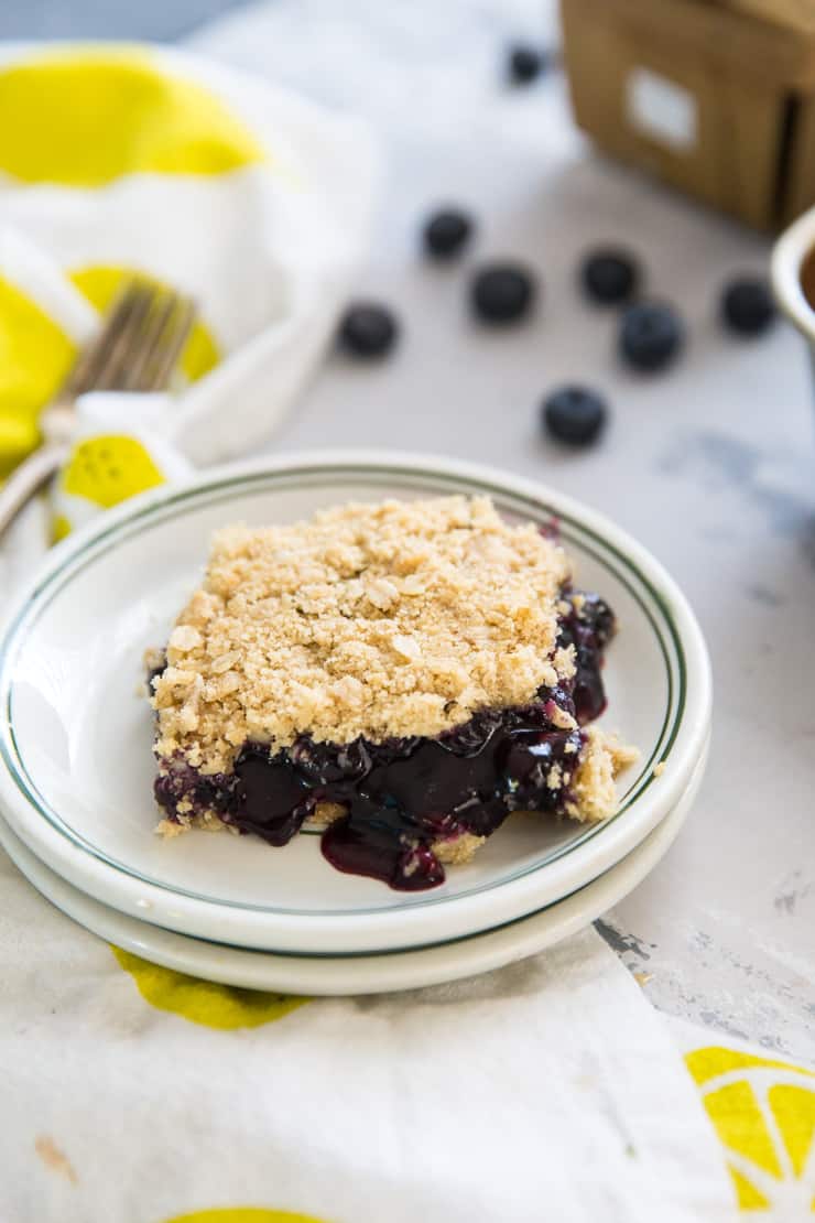 one slice of blueberry oatmeal bars on a plate with green rim