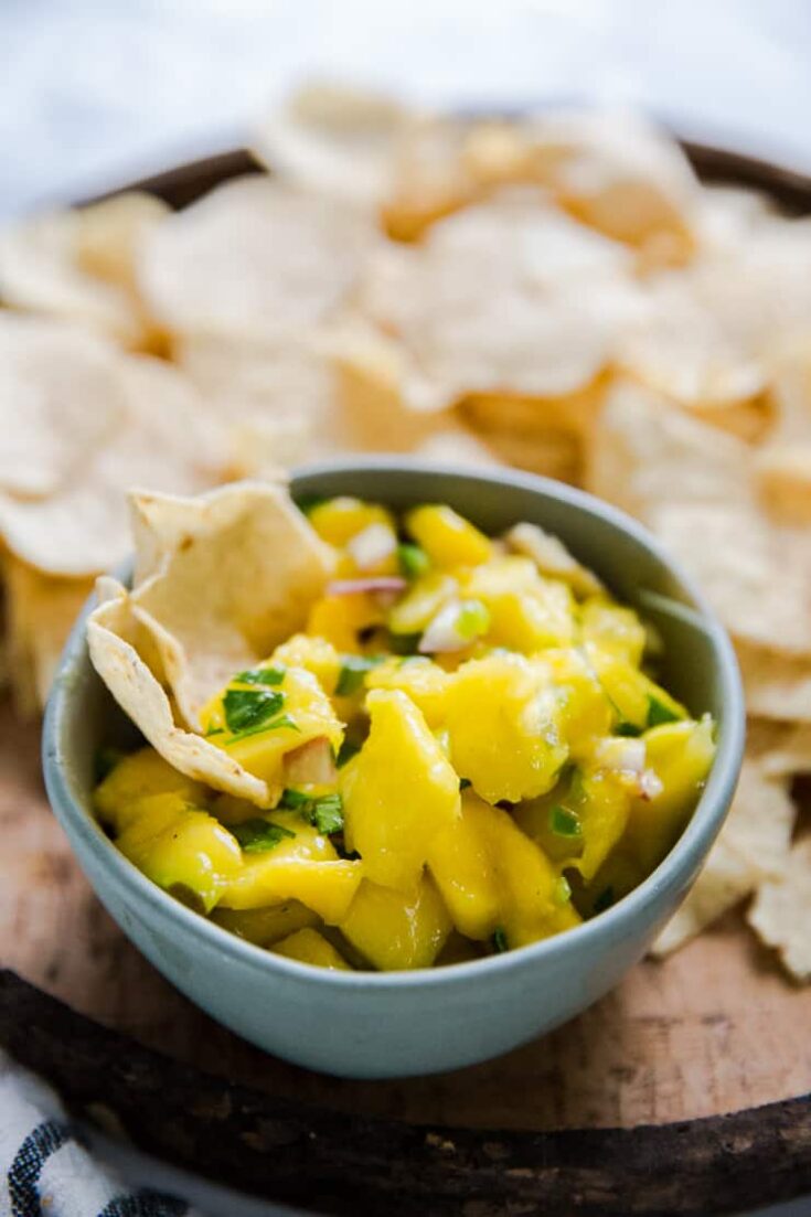 bowl of mango salsa with two chips resting in it