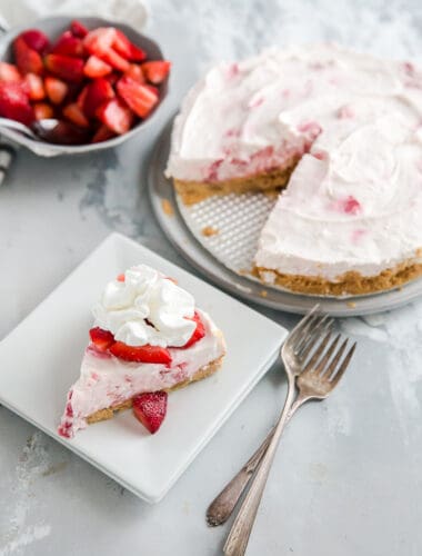 whole strawberry cheesecake with a slice on the side